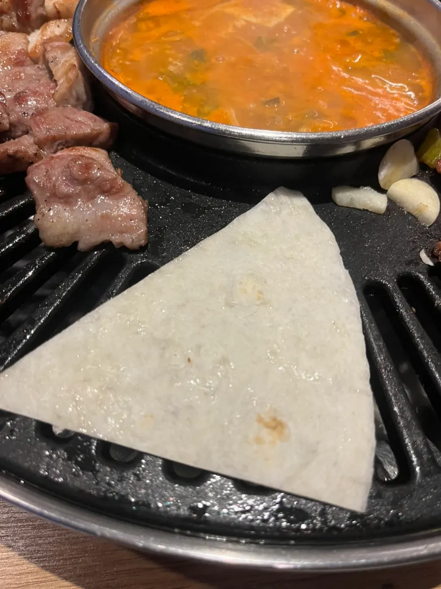 Tortilla warming on the grill plate and finished self-made taco