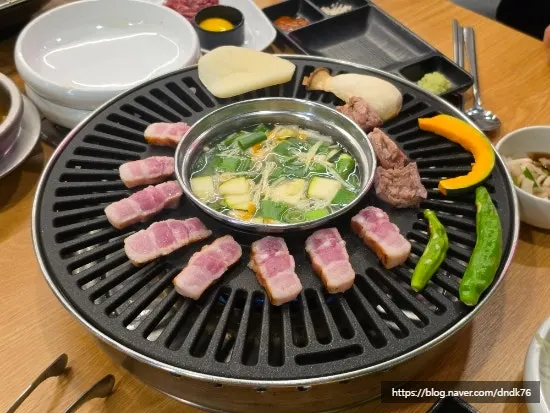 Pork belly grilling with vegetables on the pan