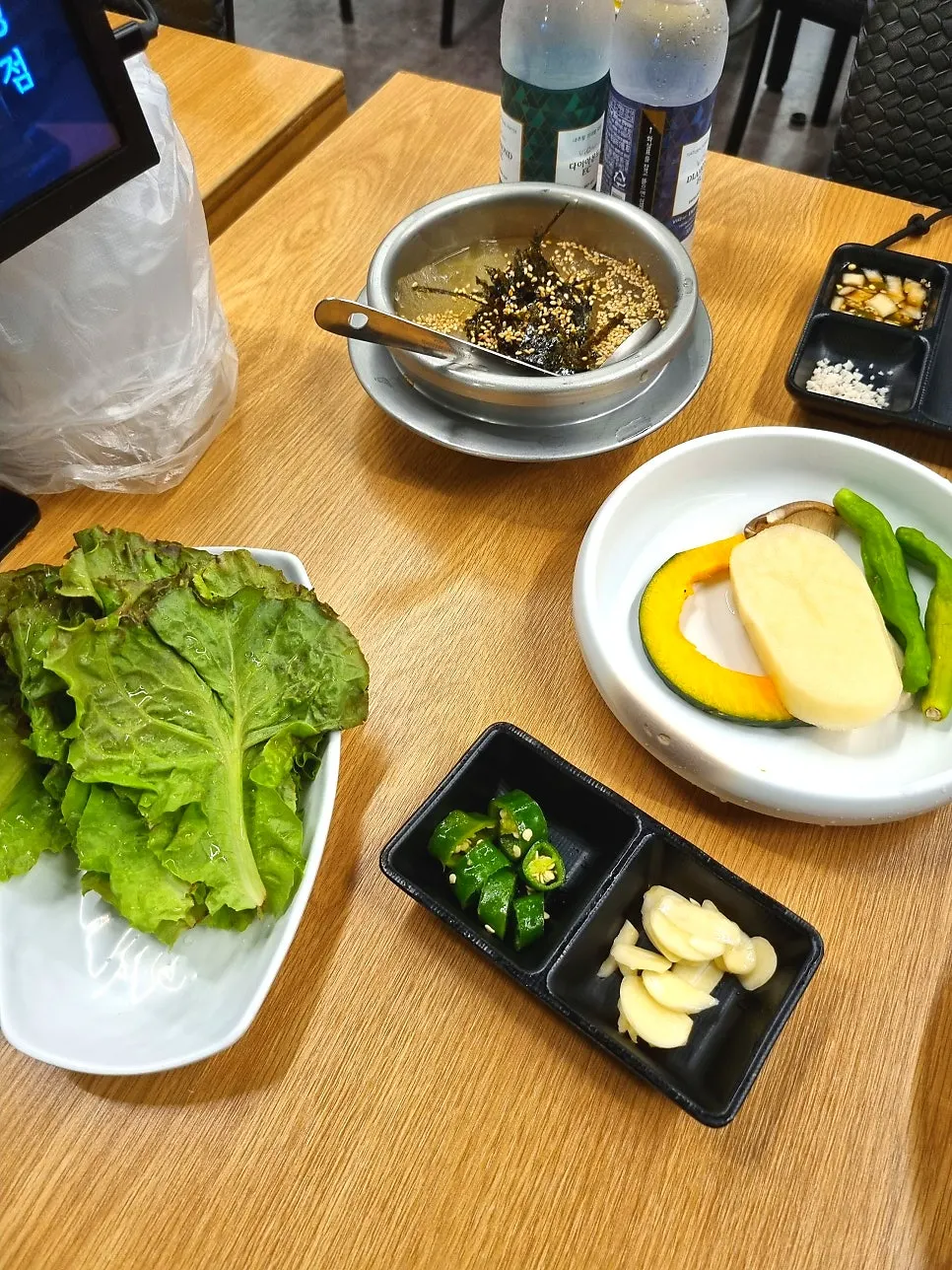 Doenjang stew in the center of the grill with side dishes