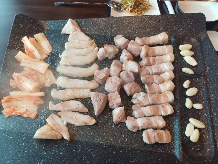 Staff grilling meat on the tabletop pan as a service