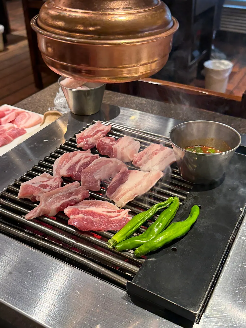 봉석쇠 위에서 익어가는 껍질 붙은 돼지고기