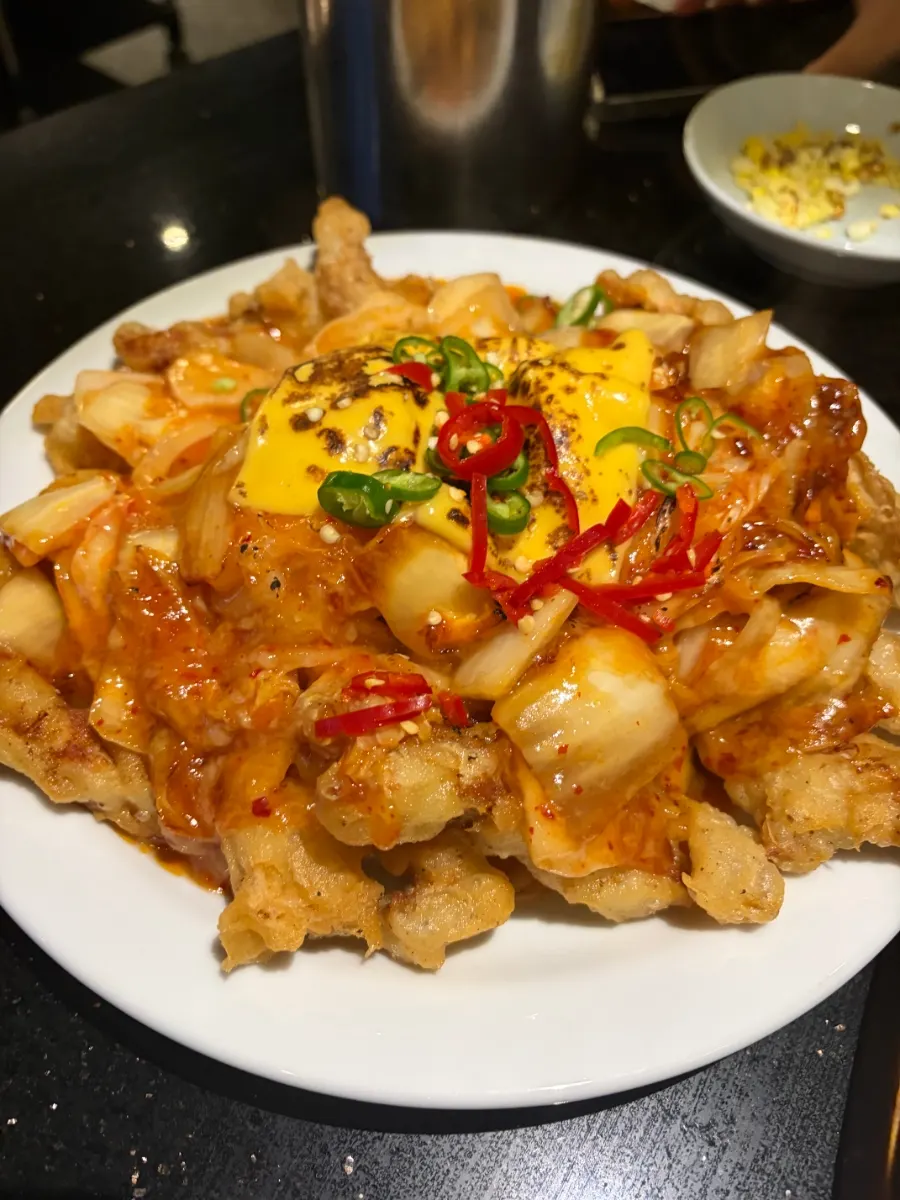 Cheese stretching from a bite of kimchi cheese tangsuyuk