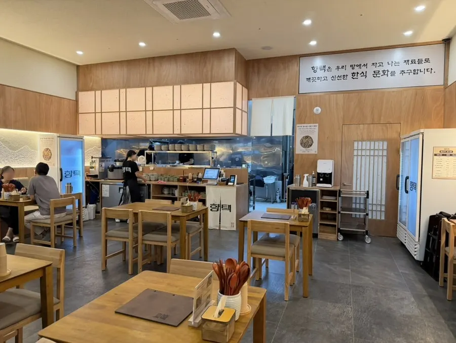 우드 프레임과 단정한 간판의 향택 입구