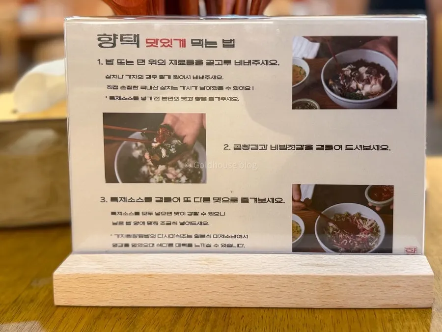 A bite of gim topped with rice and mixed salted seafood