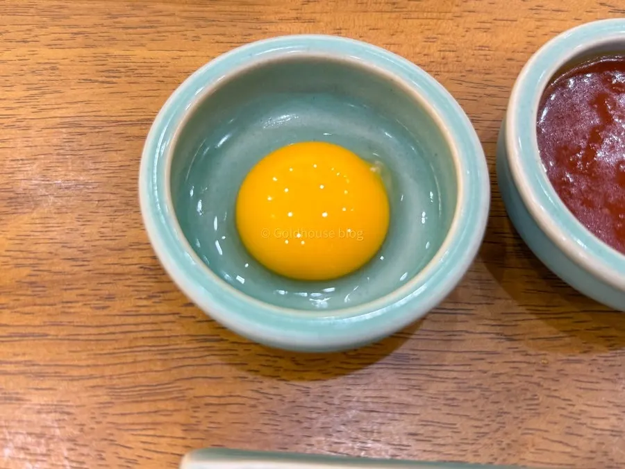 Yukhoe bibimbap topped with raw beef and egg yolk over vegetables