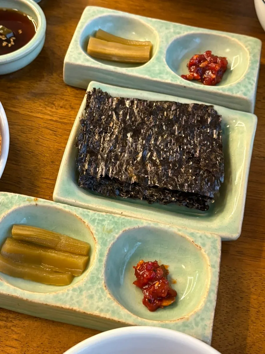 Side dishes of gopchang gim and jangajji served with the meal