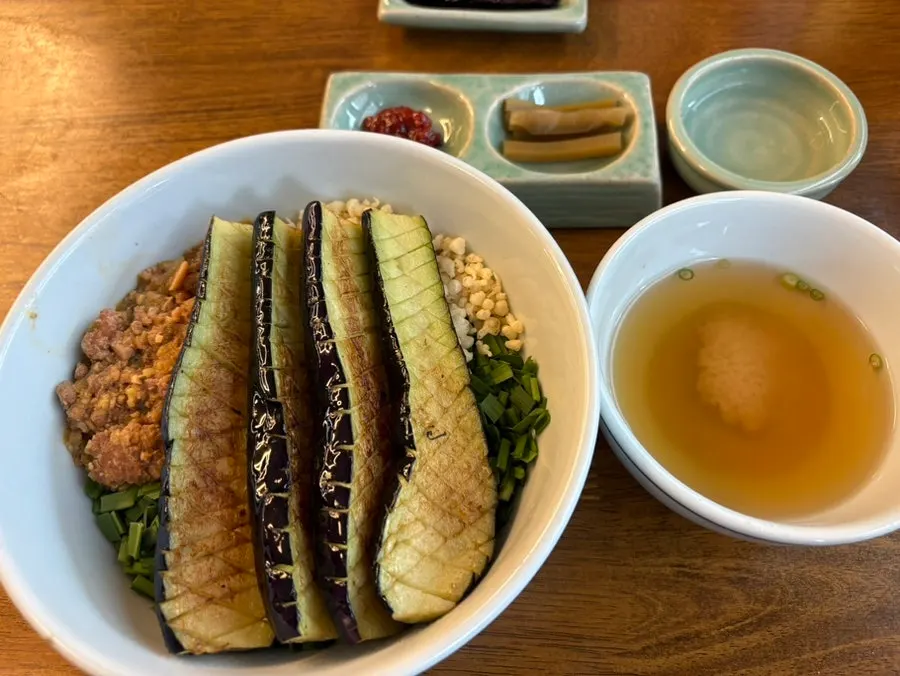 A bowl of Hyangtaek Daebong's eggplant doenjang rice bowl topped with meat