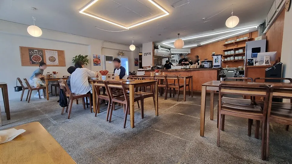 Interior del local con mesas de madera e iluminación suave