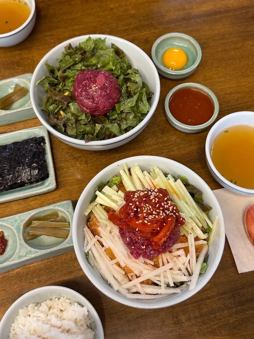 Table set with the ordered yukhoe bibimbap and pollack yukhoe mulhoe