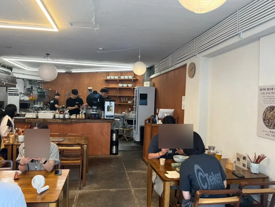 Dining hall at Hyangtaek Daebong Branch with 2- and 4-person tables