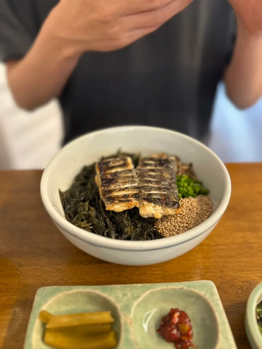 Seasoned jeotgal placed on a piece of roasted gim