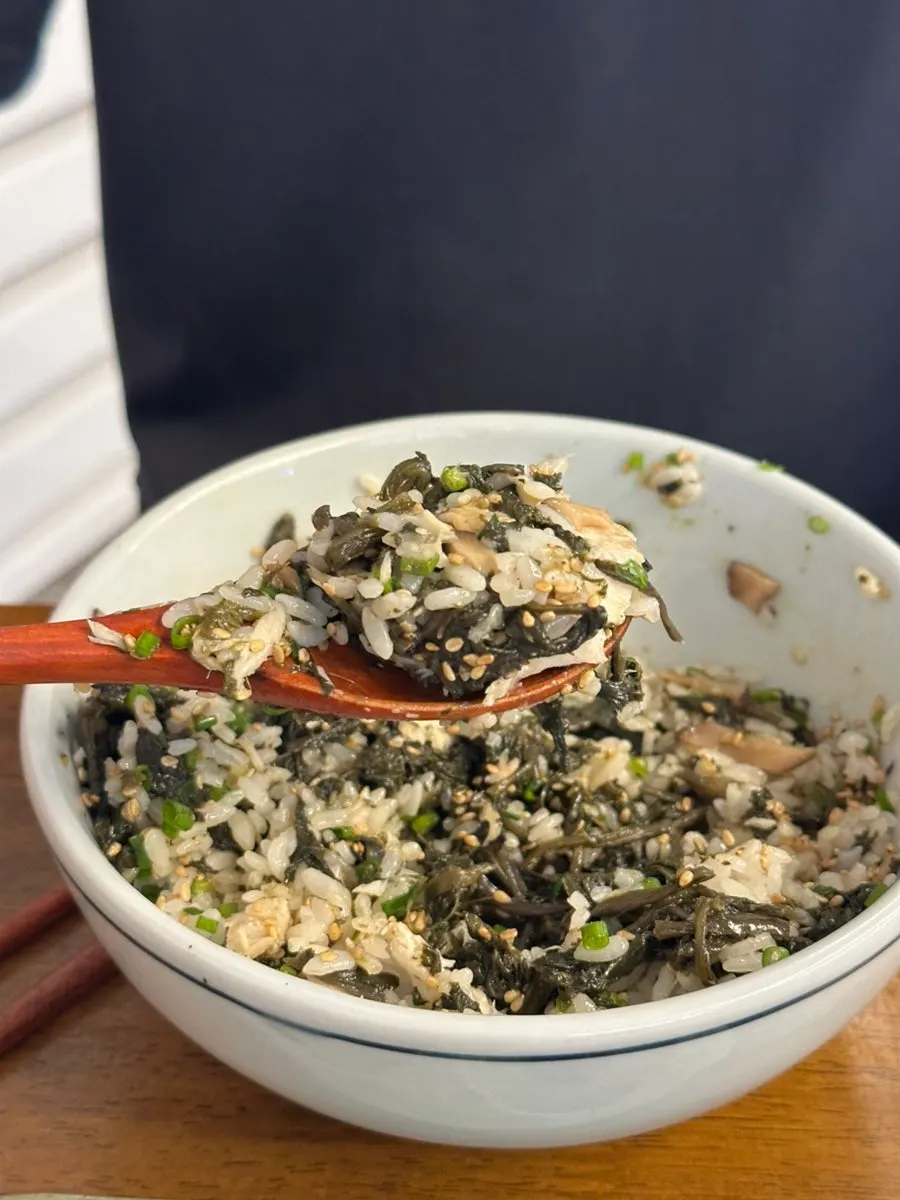 Close-up of mackerel gondre rice topped with mushrooms, chives, and sesame seeds