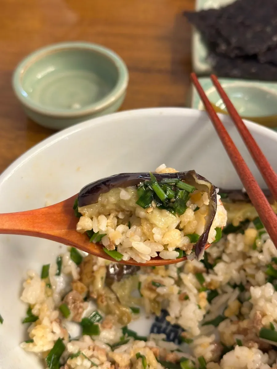 A bite of the rice bowl topped with soy sauce seasoning