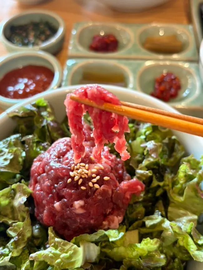 신선한 채소 위에 올린 붉은 육회비빔밥