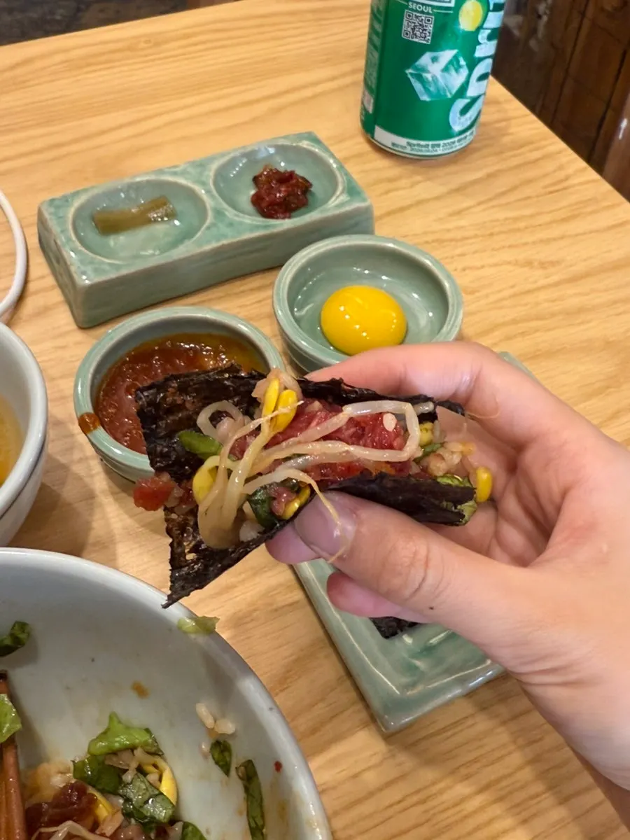 Finishing the yukhoe bibimbap with bean sprouts