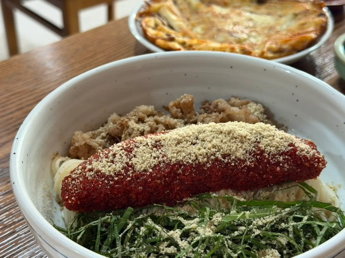 Herring roe bibim noodles topped with meat and perilla leaves