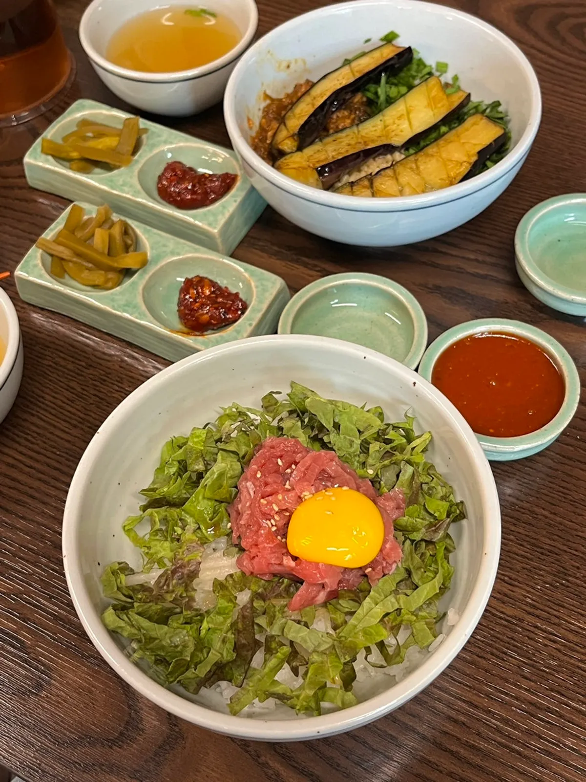Table spread with eggplant doenjang rice bowl and yukhoe bibimbap at Hyangtaek