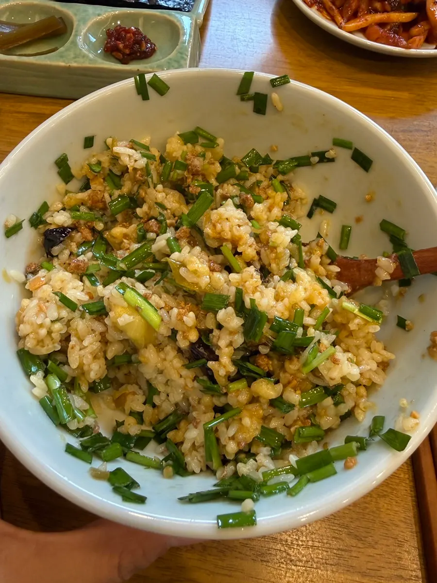 Eggplant doenjang rice bowl topped with green onions, doenjang sauce, and fried batter bits
