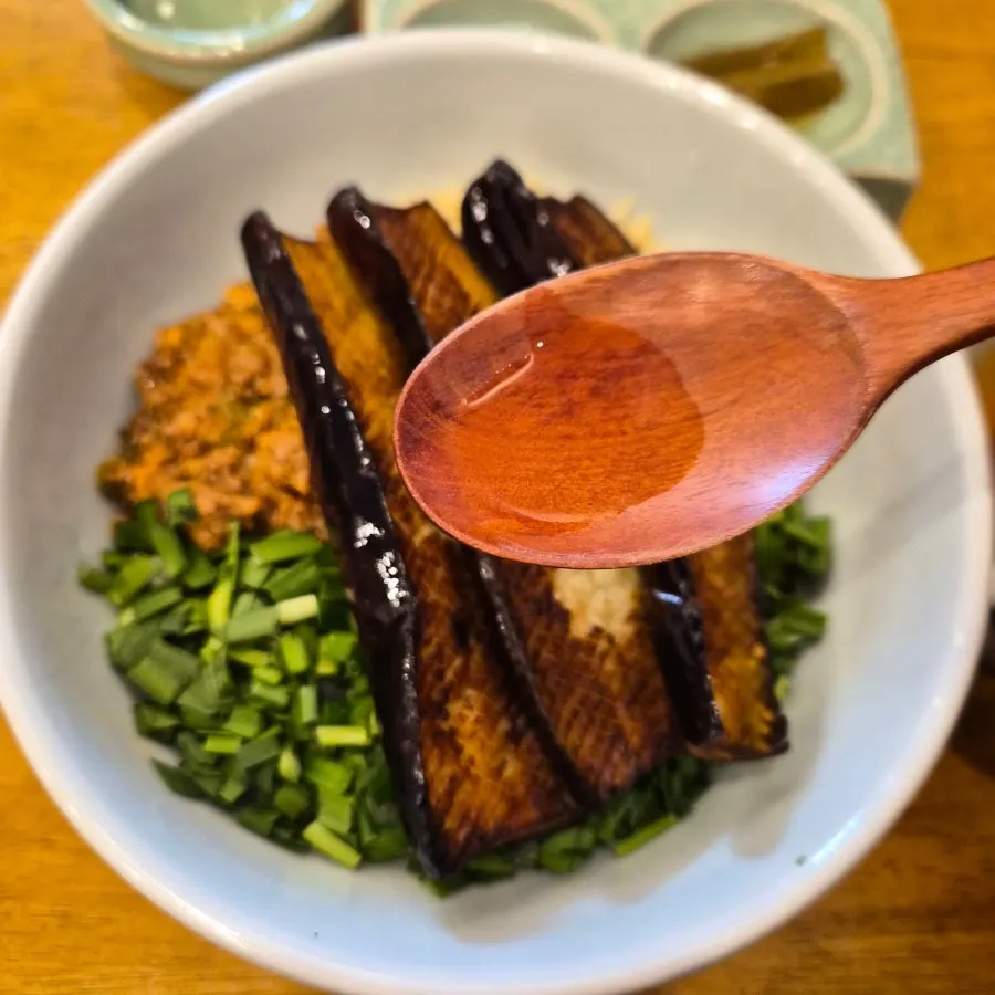 Close-up of doenjang and vegetables layered on the rice bowl