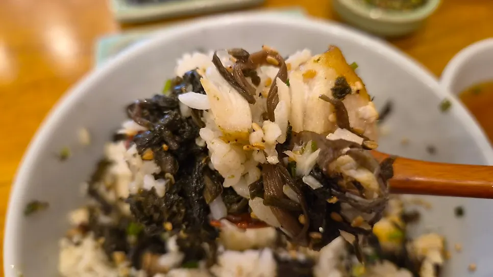 A spoonful mixing mackerel and thistle rice