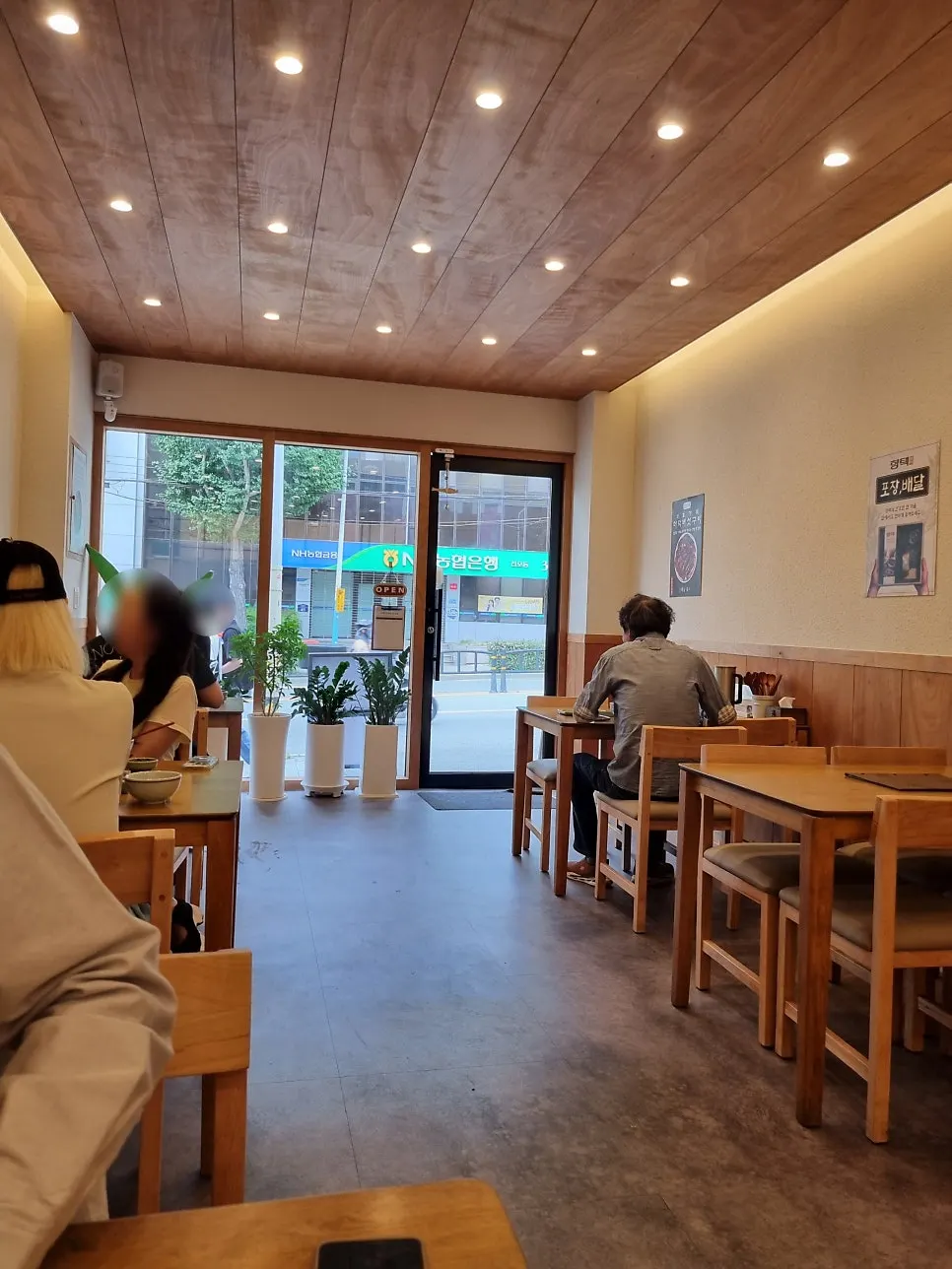 Wood-toned interior of Hyangtaek Jeonpo Branch filled with customers
