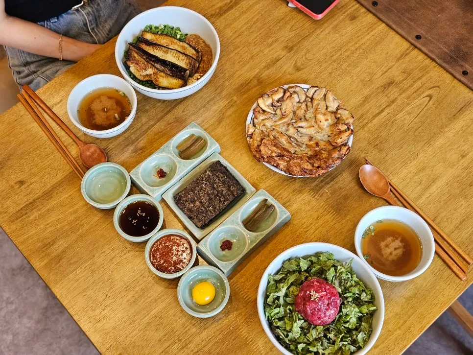 Table set with eggplant deonjang rice and yukhoe bibimbap