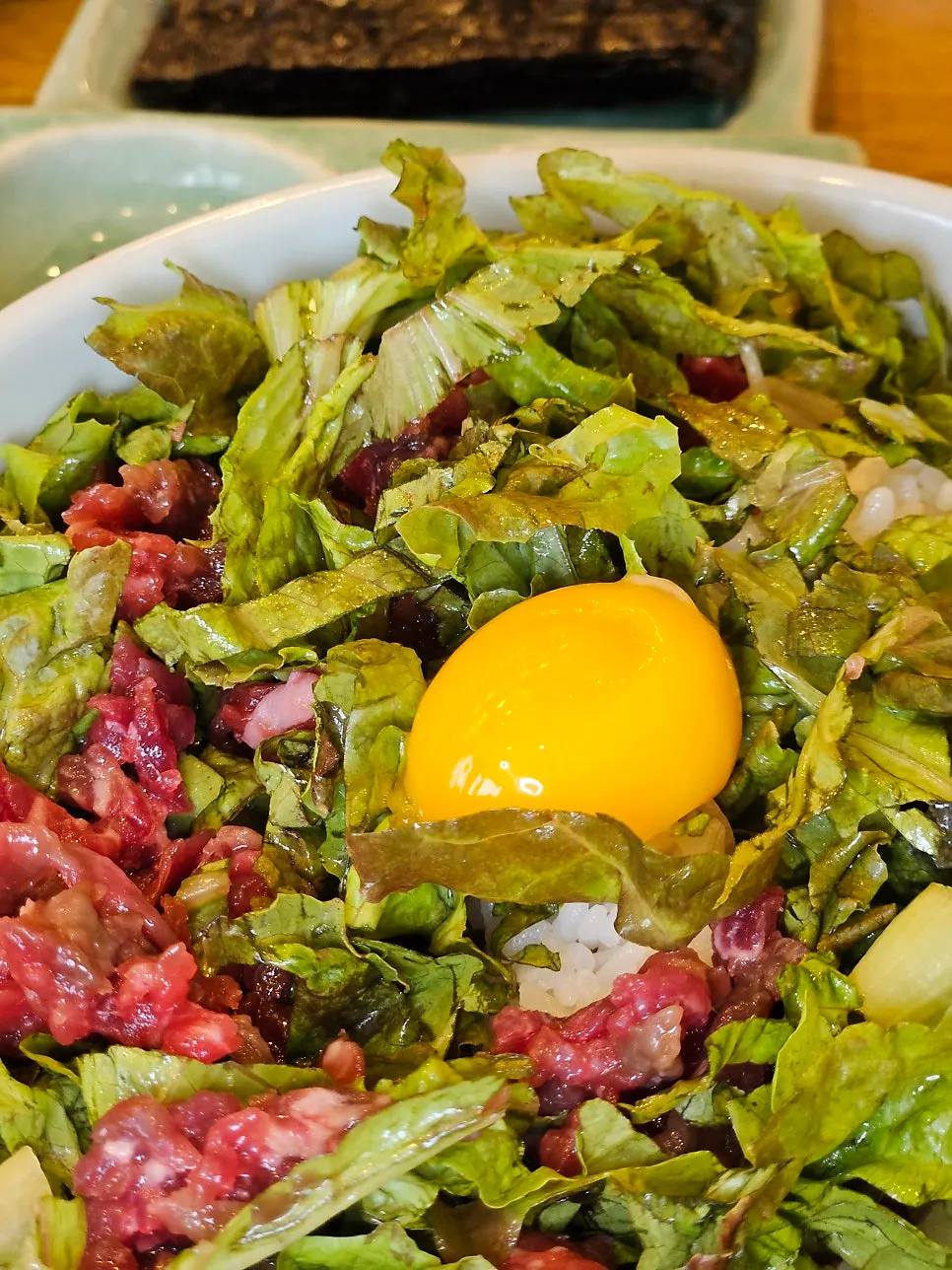 Yukhoe bibimbap topped with an egg yolk
