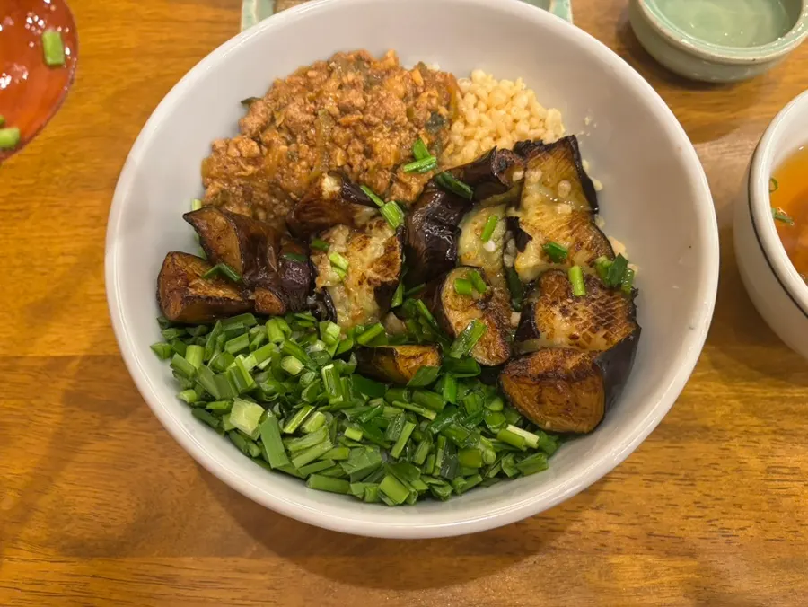 Eggplant doenjang rice bowl topped with scored eggplant and green onion