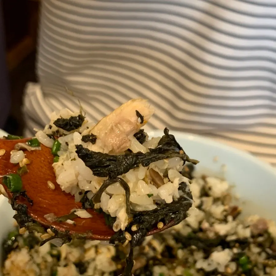 Close-up of rice topped with mackerel and gondre greens