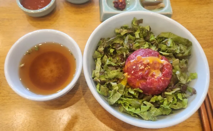 Bibimbap topped with egg yolk over the yukhoe