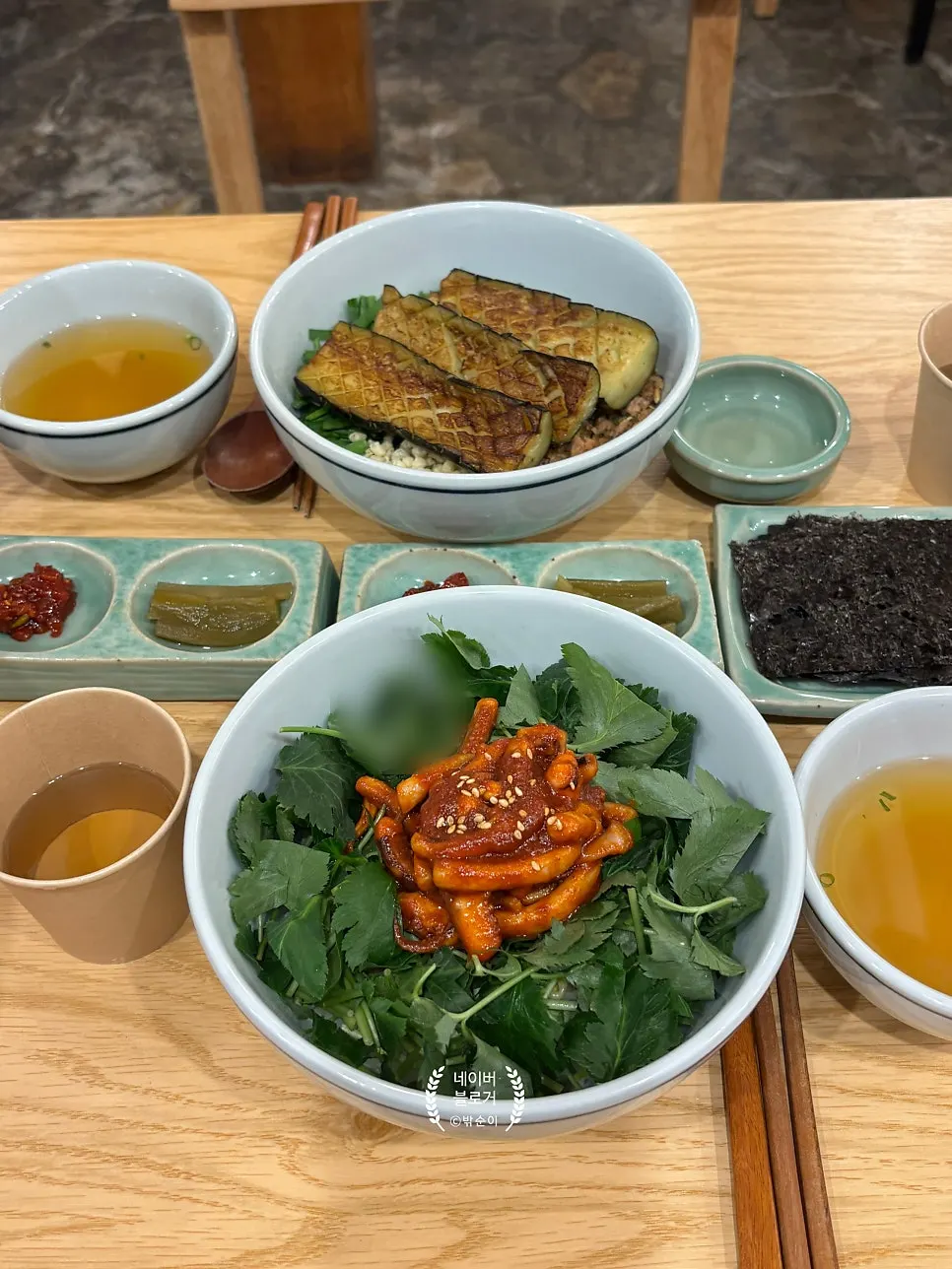 Table setting with eggplant doenjang rice bowl and chamnamul squid rice bowl