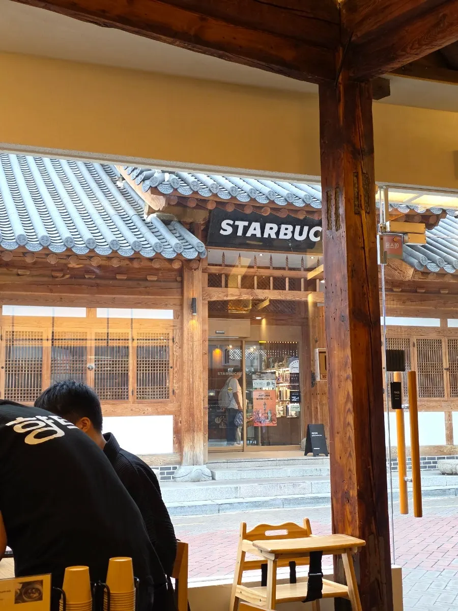 The owner explaining the menu, with the street view out the window