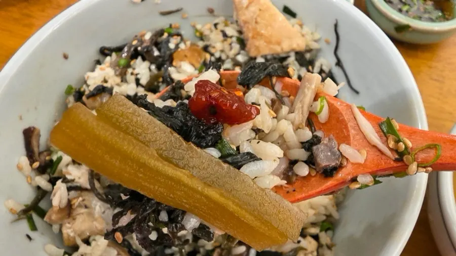 A piece of mackerel flesh lifted with chopsticks