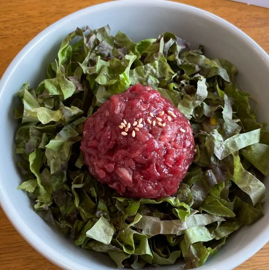 A bite of gondre rice and mackerel placed on gopchang dolgim