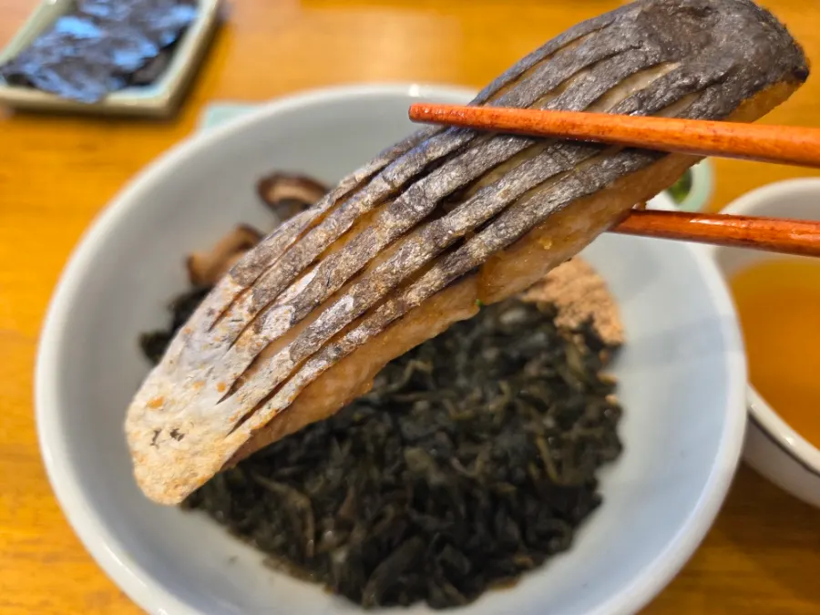 Close-up of mackerel on top of gondre greens and mushrooms