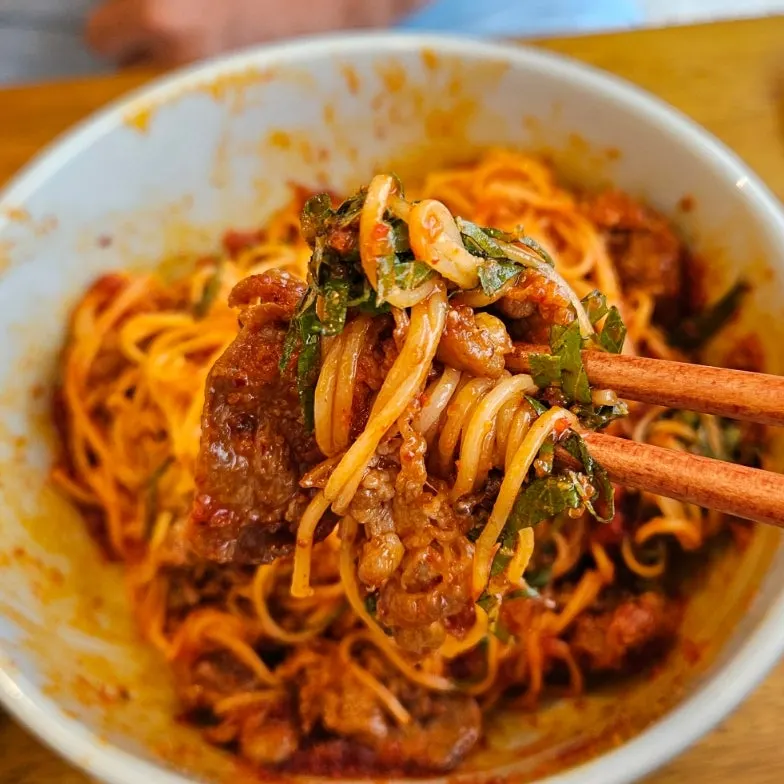 Thin noodles mixed with beef brisket and perilla leaves for the herring roe bibim noodles