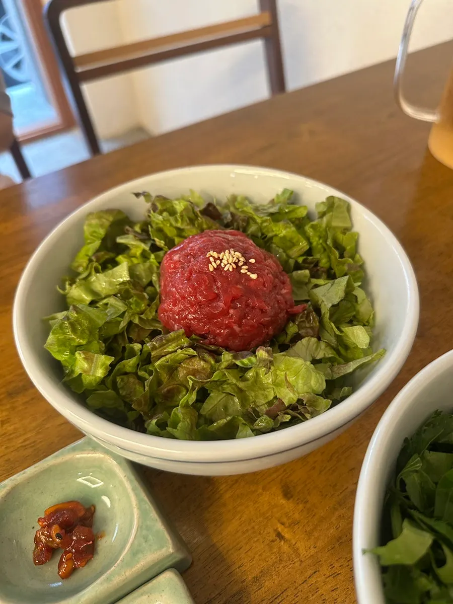 Yukhoe bibimbap topped with lettuce and raw beef