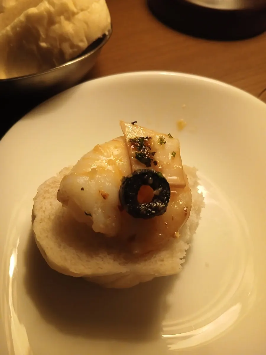 Warm bread served alongside the gambas