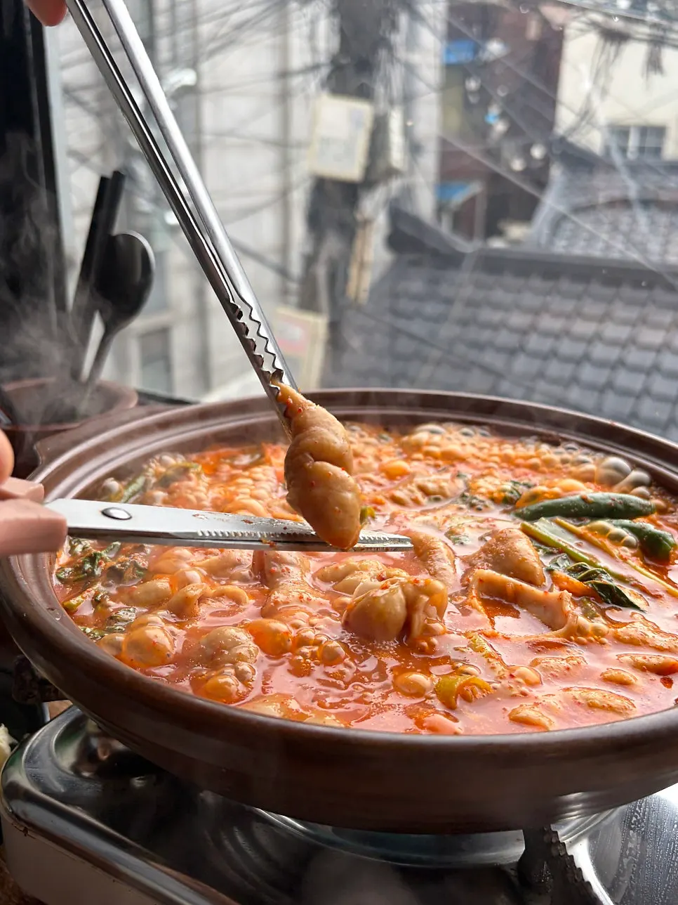 A ladle of spicy broth and chewy gopchang