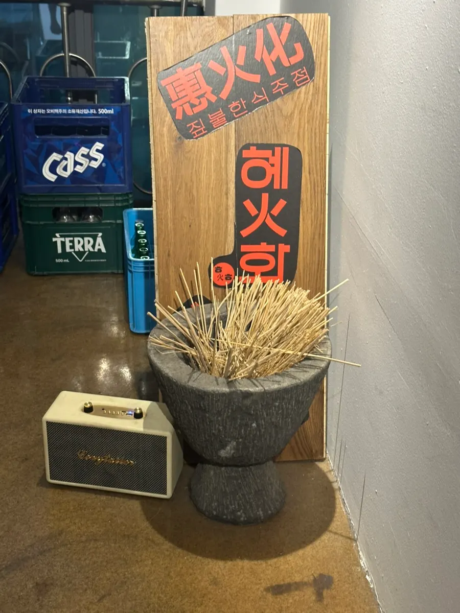 혜화화 매장 입구 쪽 간판과 짚불 장식 인테리어