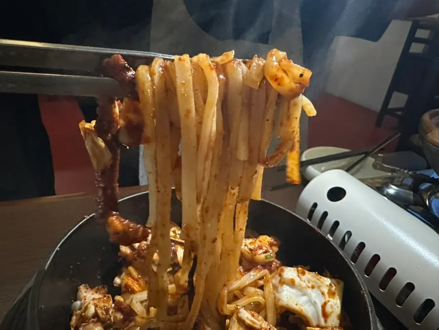양념과 섞여 끓는 낙지볶음 아래 칼국수면