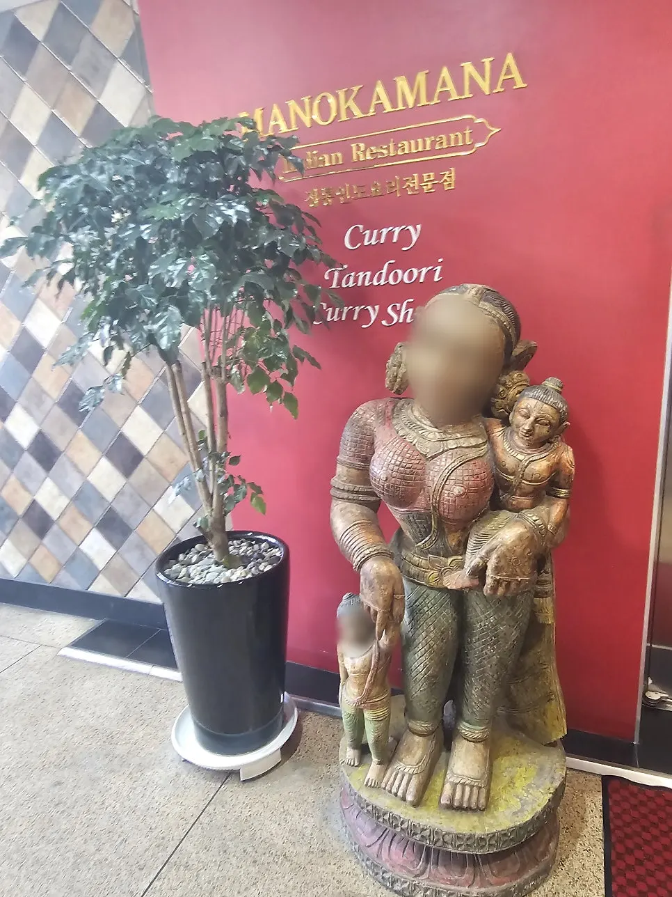 Restaurant entrance with red walls and Indian-style sculptures