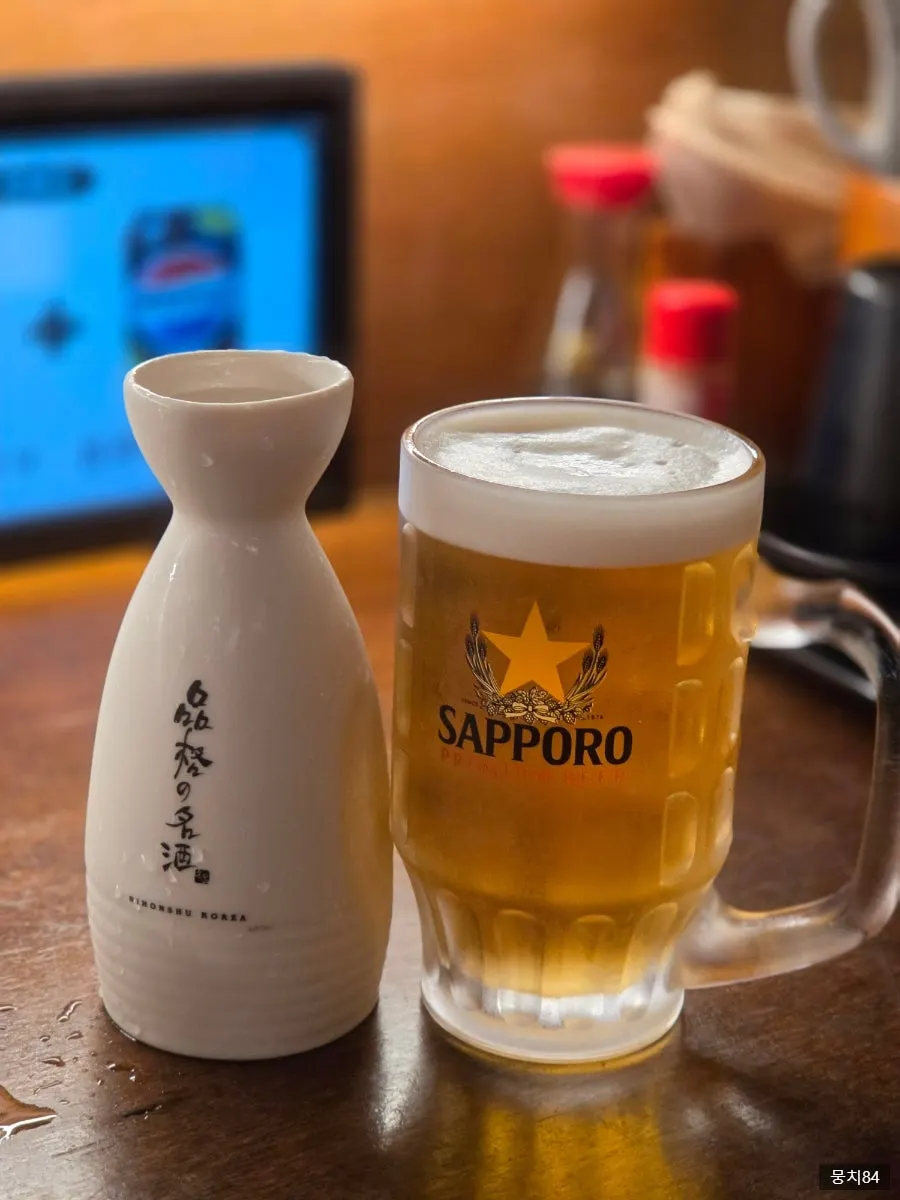 A glass of cold sake and Sapporo draft beer