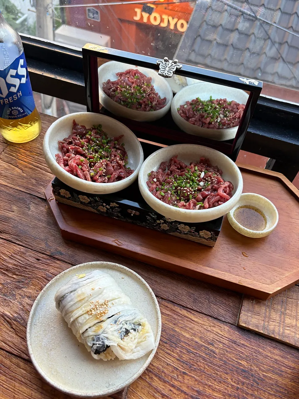 Beef tartare & aged kimchi egg sushi served in a ceramic bowl