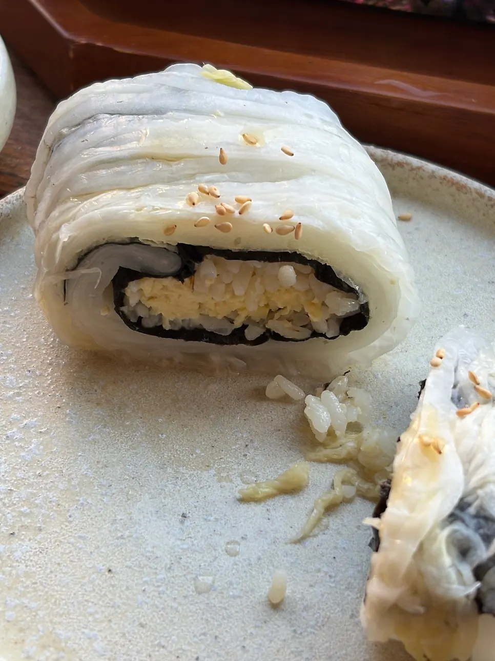 Cross-section of egg sushi tucked inside aged kimchi