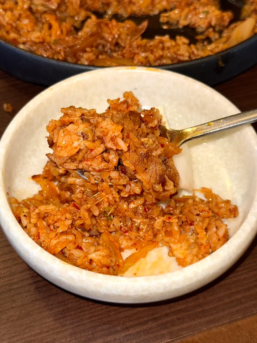 A spoonful of kimchi fried rice mixed with cheese and beef brisket