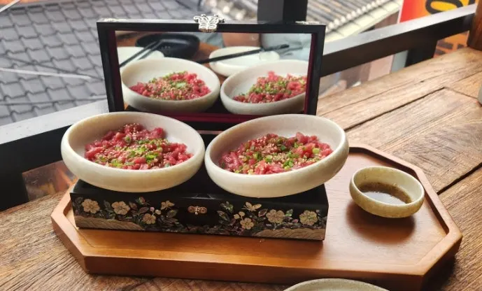 냄비 위 석쇠에 올려진 짚불 초벌 곱창과 닭