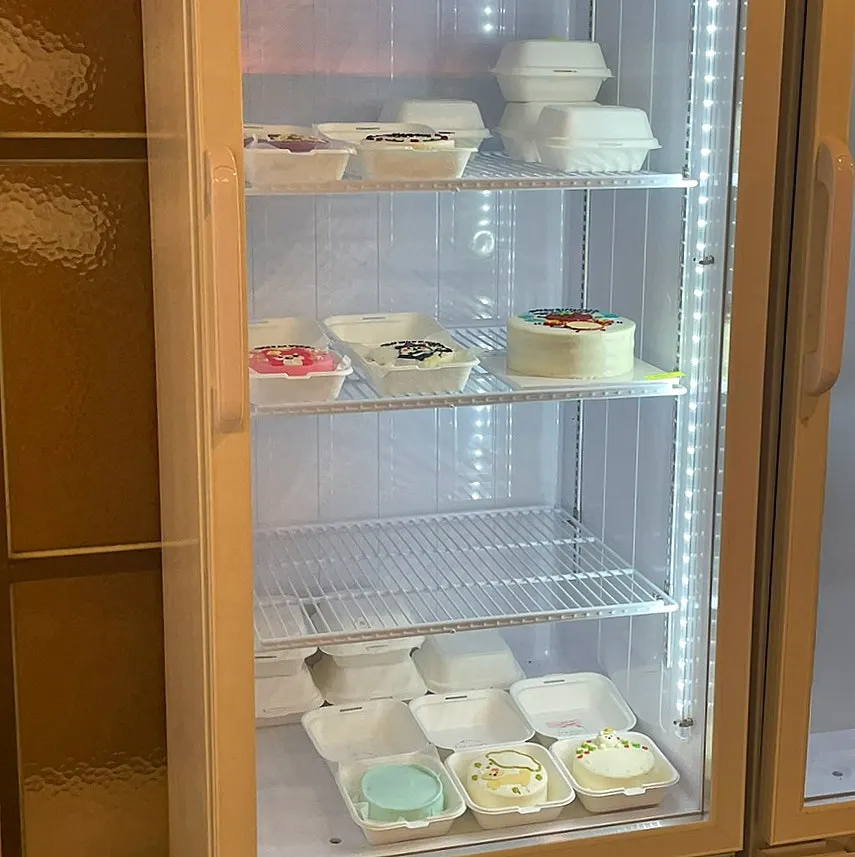 Lettering cakes lined up in the fridge