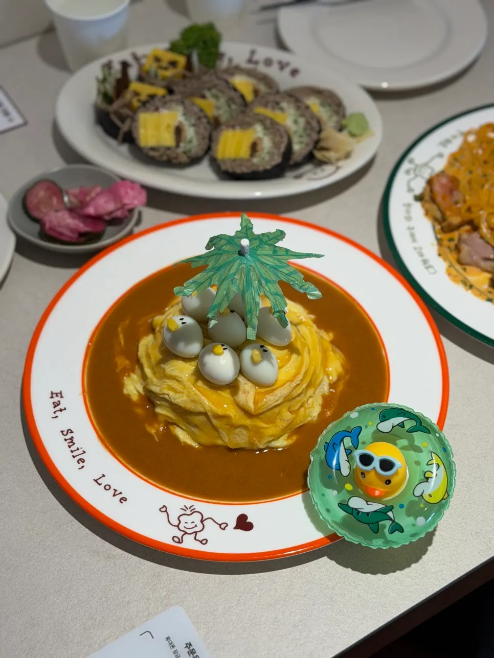 Omurice topped with tiny ducks and a green parasol