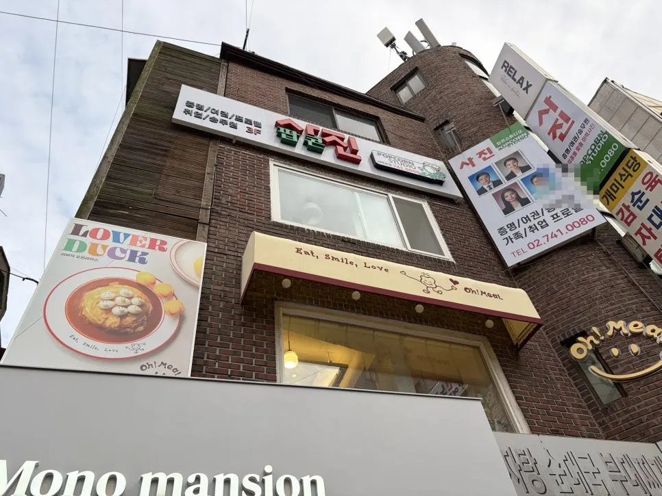 골목에서 올려다본 오밀 노란 간판